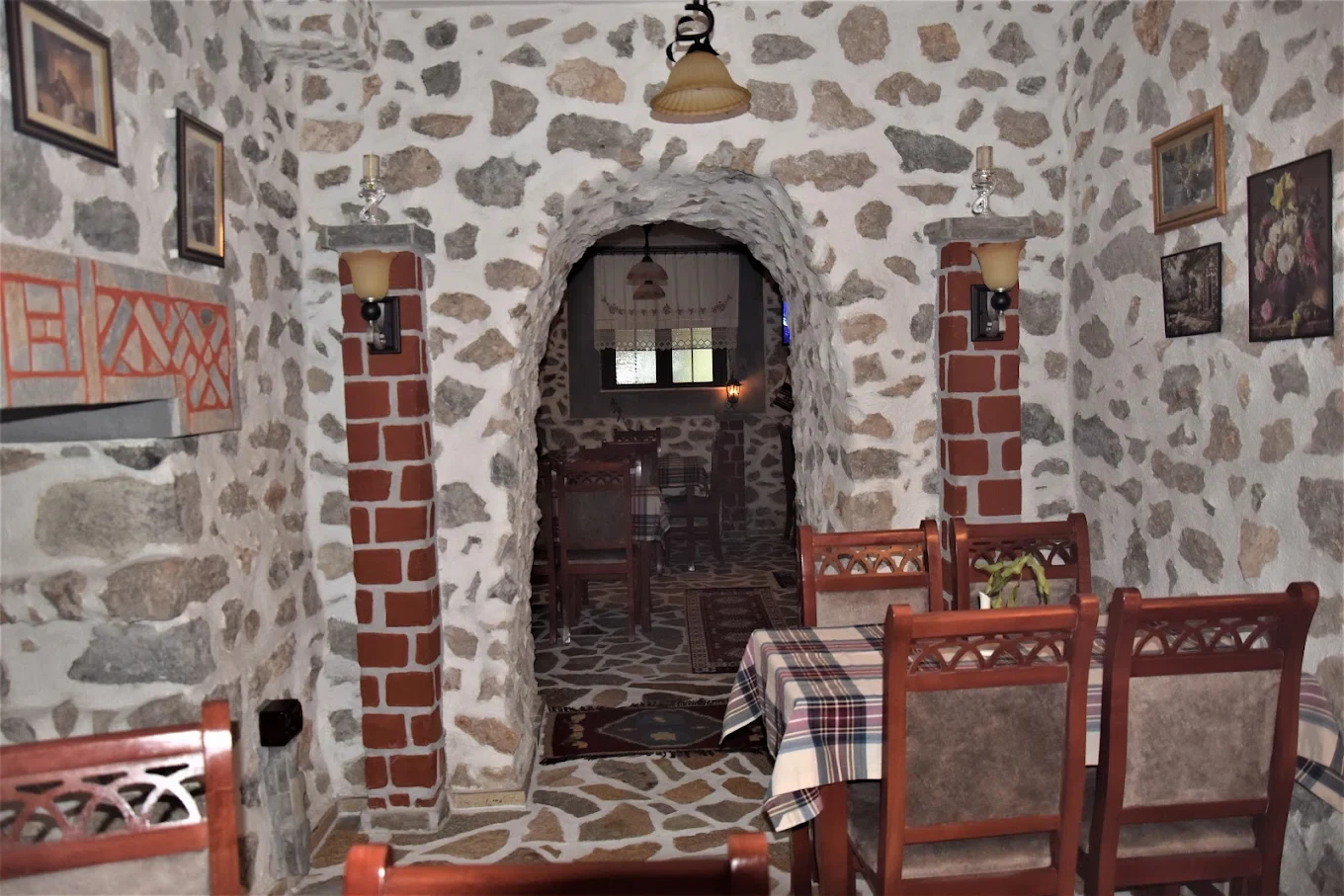Stone archway, brick details and wooden tables inside Tradita Shqiptare.